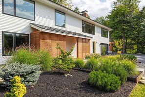 Una casa moderna de dos pisos con un jardín ajardinado.