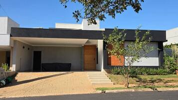 Un edificio moderno con techo plano, acceso cubierto y entrada pavimentada.