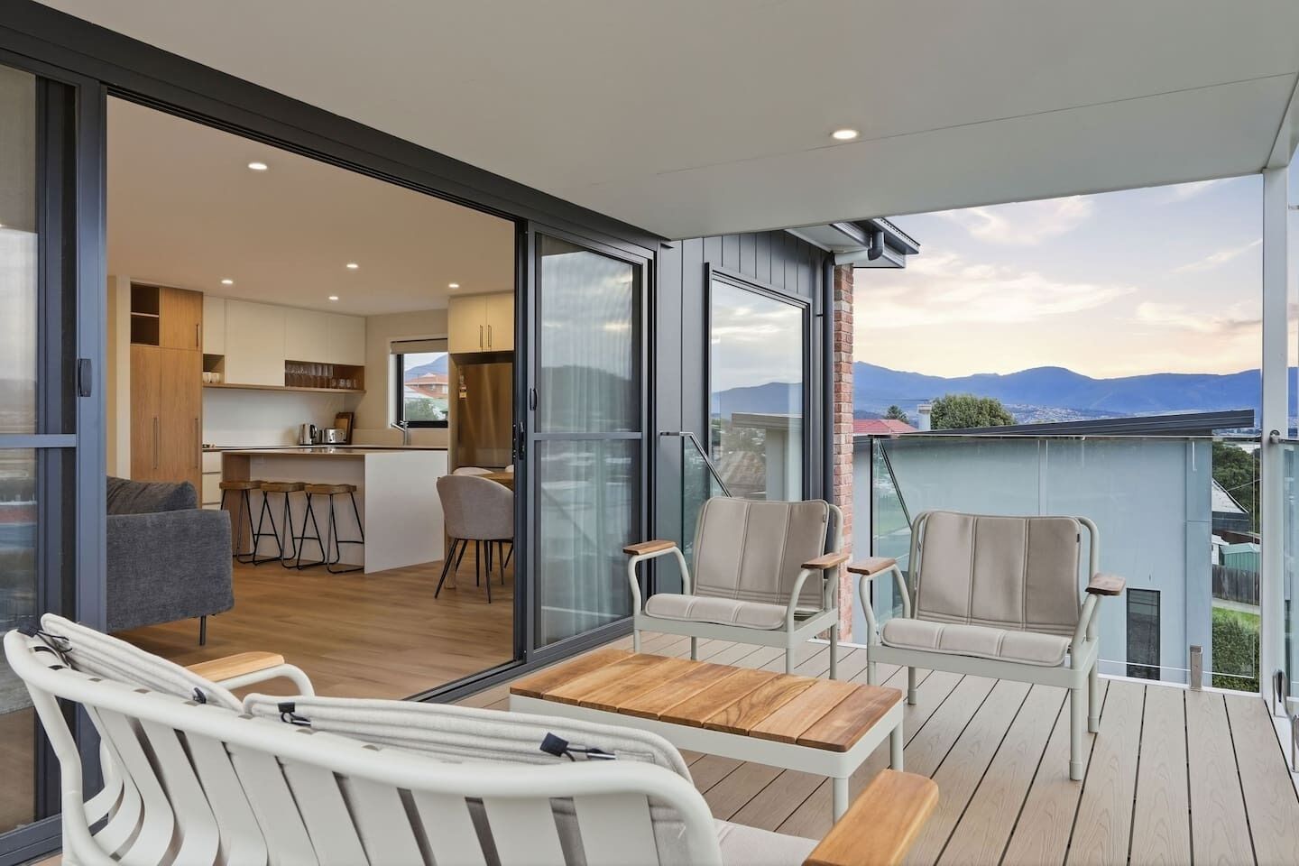 A modern apartment with a balcony, a kitchen, and a dining area.