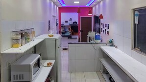 Eine moderne Küche mit weißen Schränken, einer zentralen Kochinsel und einem Fliesenboden.
