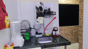 A compact kitchen with a sink, a blender, a kettle, and a coffee maker.