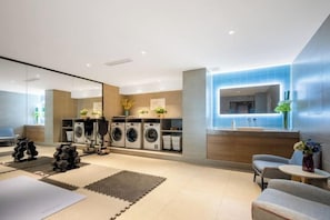 A modern hotel room with a large mirror, a washing machine, a sofa, and a small table. - Homeinn · neo (Xi'an Daming Palace National Heritage Park Daming Palace North Subway Station) (Xi'an)
