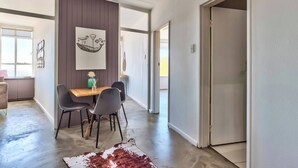 A modern dining area with a wooden table, two chairs, a cowhide rug, and a wall-mounted artwork. - Table Mountain Escape, Mountain and sea Views (Cape Town)