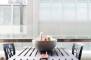 Ein Balkon mit Tisch, Stühlen und einer Pflanzenschale.