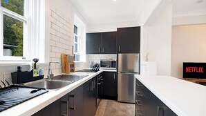 Eine moderne Küche mit einem Edelstahl-Kühlschrank, einer Mikrowelle und einem Spülbecken.