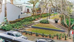 A residential area with houses, a pathway, and a car parked on the street. - Spacious 2 bedroom apt with parking (Surry Hills)