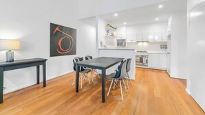 A modern kitchen with white cabinets, a microwave, and a stove. - Spacious 2 bedroom apt with parking (Surry Hills)