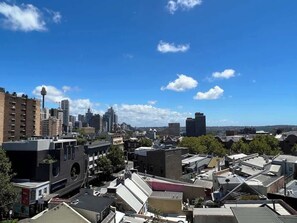 Eine Skyline mit Wolkenkratzern, einem markanten Turm und einer Mischung aus Wohn- und Geschäftsgebäuden.