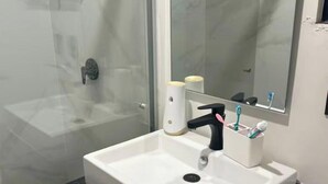 A bathroom with a white sink, black faucet, and a mirror above it.