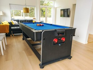 A pool table in a room with a sofa, a television, and a window. - 5 Star Holiday Home in Saltum (Saltum)