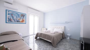 A bedroom with a bed, bedside tables, a painting, and a window.