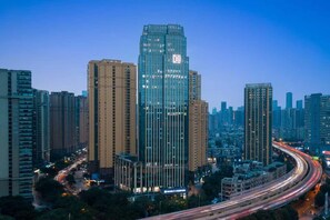 Un paisaje urbano con edificios altos, una autopista curva y un cielo despejado.