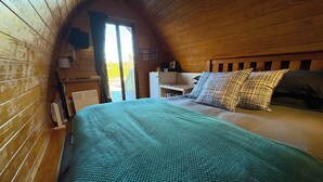 A cozy room with a bed, a desk, and a window.