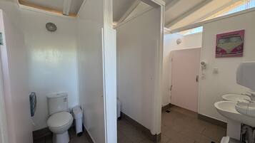 A bathroom with a toilet, bidet, and a sink.