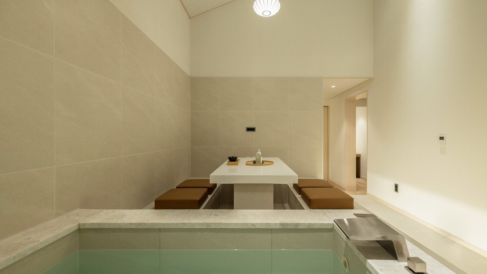 Un baño moderno con lavamanos central, bañera y zona de ducha.