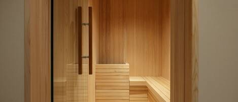 Una sauna con bancos de madera y puerta de vidrio.