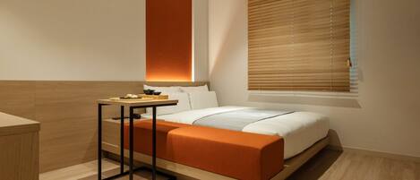 Una habitación de hotel moderna con cama, mesita de noche y ventana con persianas.