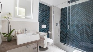 Une salle de bain moderne dotée d’un grand lavabo, de toilettes et d’un espace douche.