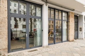 Ein Gebäude mit großen Glasfenstern, einer Steinfassade und einer Tür.
