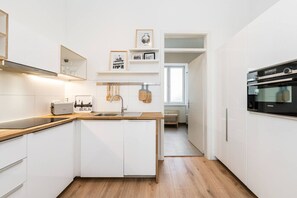A modern kitchen with white cabinetry, a built-in oven, and a toaster. - Stylish New Cube Loft by Berlin Wall Apartments (Berlin)