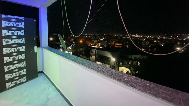 A balcony with a view of a cityscape at night.