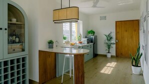 Une cuisine moderne dotée d’un îlot central, d’un meuble à vin intégré et d’une porte en bois.