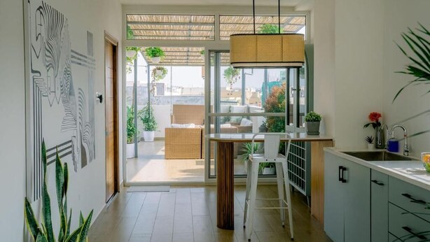 Una cocina moderna con comedor, ventanas amplias y vista a la ciudad.