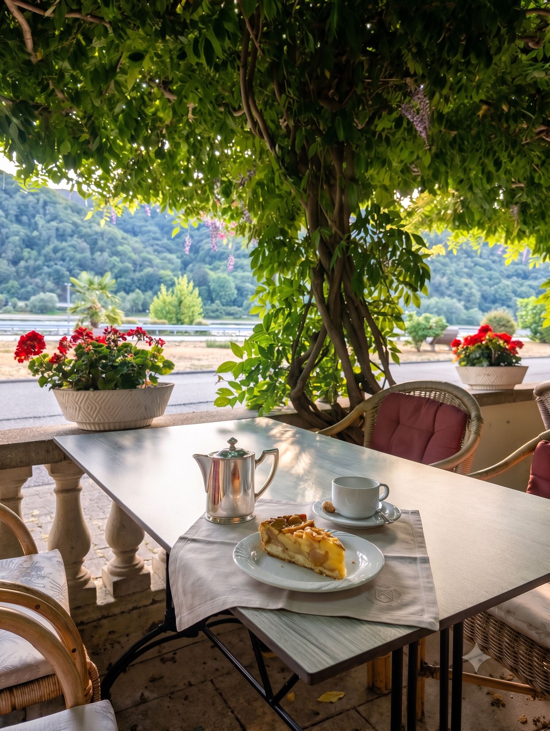 Ein Essbereich im Freien mit einem Tisch für zwei Personen, einer Karaffe, einer Tasse und einer Kuchenstück.