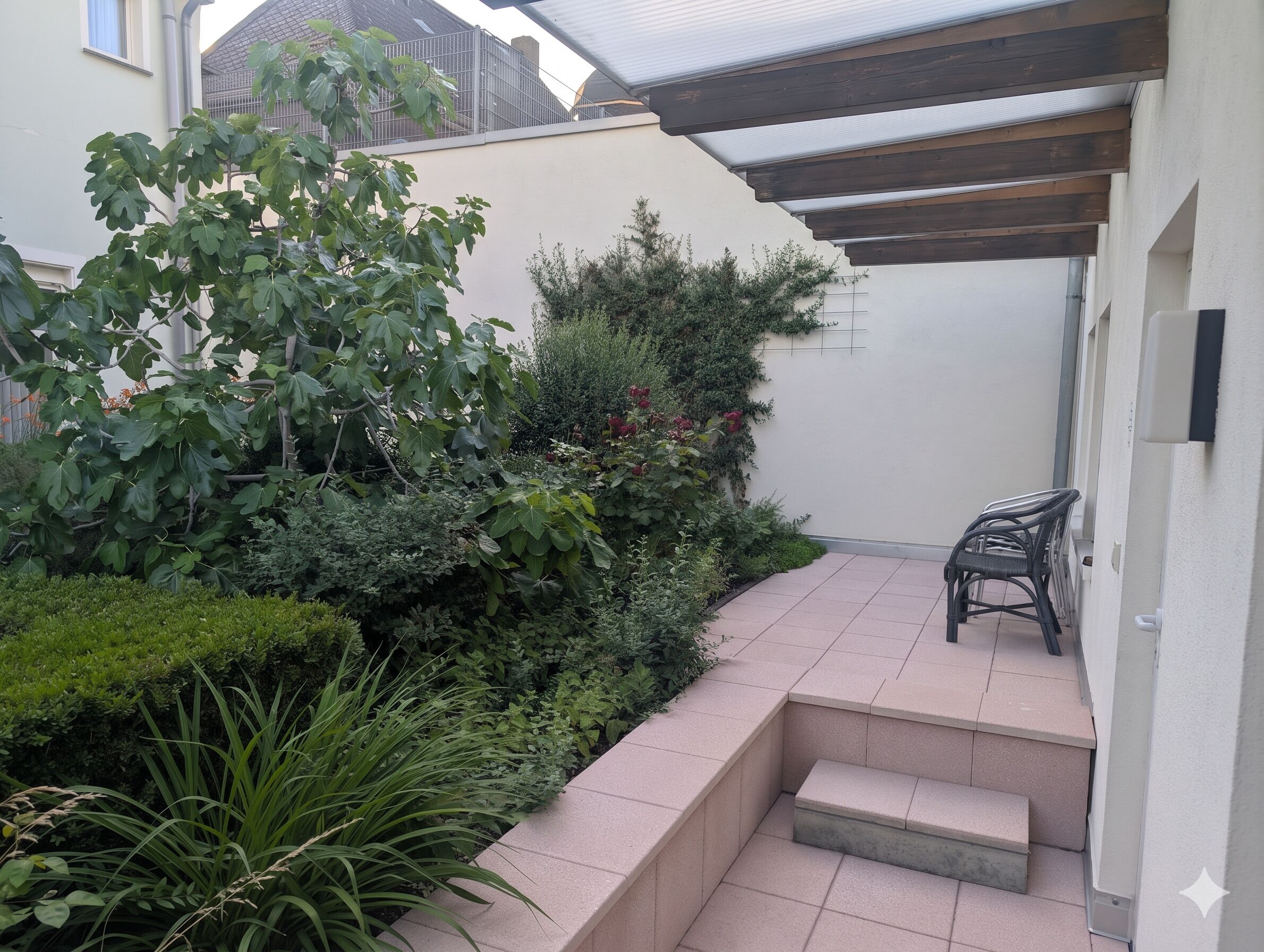Um jardim residencial com um alpendre, degraus e uma cadeira.