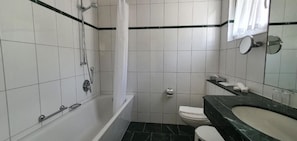 A bathroom with a bathtub, toilet, and sink.