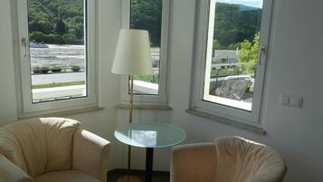 Habitación doble Deluxe, balcón | Área de sala de estar | Juguetes y impresora