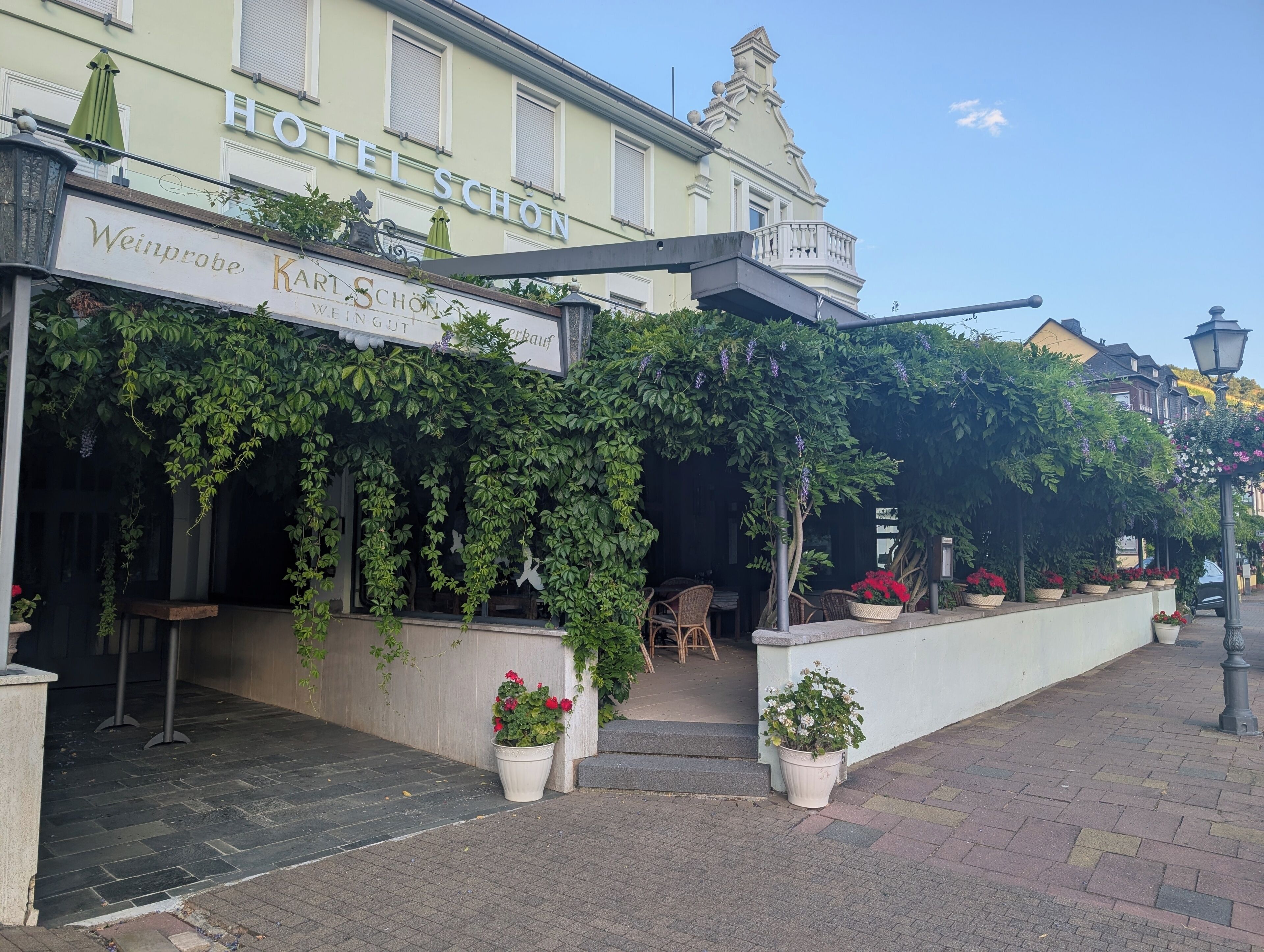 A hotel with a sign reading 'Hotel Schön' and 'Weinprobe Karlsruhe Werkauf.'