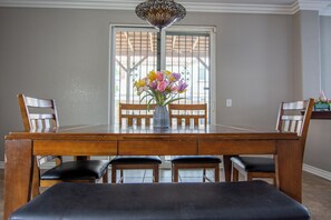 A dining table with chairs, a vase with flowers, and a decorative ceiling light. - Beautiful 4 Bedroom - Fun Family Pet Friendly Home (Lancaster)