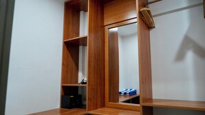 Un armario de madera con varios compartimentos y una barra para colgar.