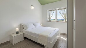 Una camera da letto con un letto, comodini, una finestra con tende e vista sull'esterno.