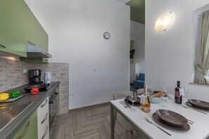 A modern kitchen with a dining area set for a meal. - Wabi Sabi Apartment 7 (Krk)