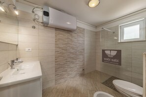 Ein modernes Badezimmer mit Waschbecken, Toilette und Dusche.