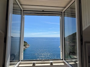 A view through a window with a clear sky and a coastline. - Sweet Place by Jasminka (Tisno)