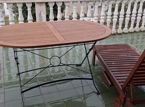 A round table with a metal frame and a bench with a wooden slat design.