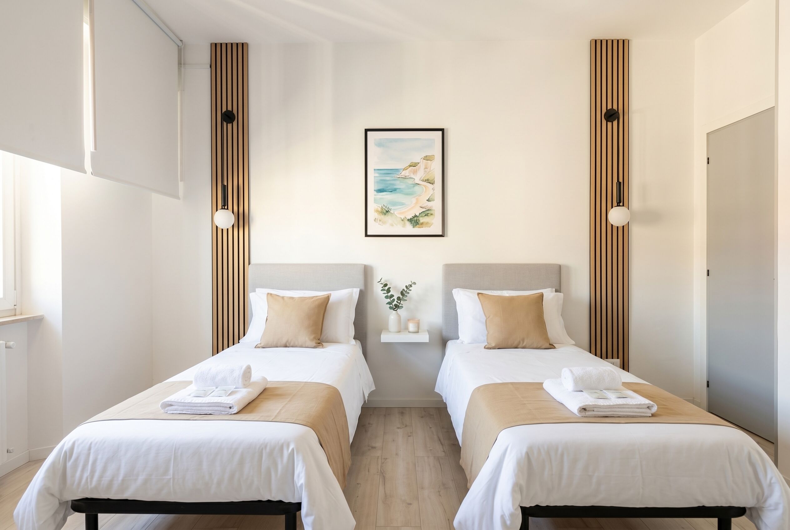 A hotel room with two beds, a painting on the wall, and a small shelf with a plant.