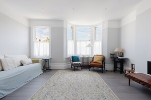 A room with a bed, a chair, a table, and a lamp. - Sunny 3BDR Family Home in Clapham (Greater London)