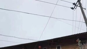 Un edificio de varios pisos con techo de tejas, múltiples ventanas y una entrada visible.
