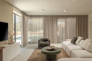 A modern living room with a sofa, armchair, and round coffee table. - Nareo Villa Collection With Private Pool (Sveta Nedelja)