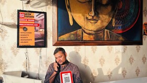 Un mostrador de recepción con una computadora, un teléfono y un cartel publicitario de M2N Hotels.