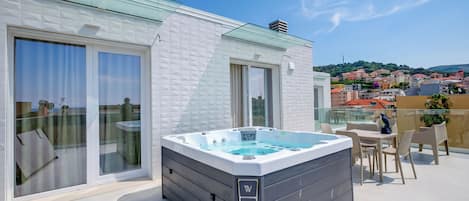 Un jacuzzi en un balcón con vistas a la ciudad.