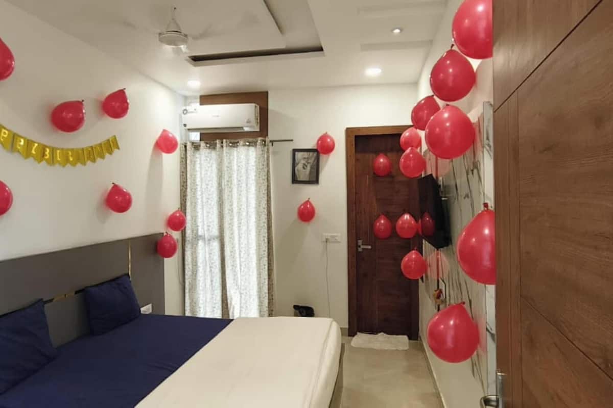 Ein Schlafzimmer mit einem Bett, einem Holzschrank und roten Ballons.