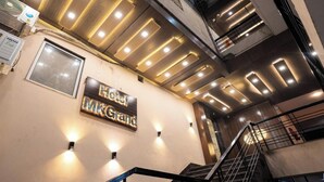 A hotel interior with a staircase, a sign reading 'Hotel MKGrand,' and recessed lighting. - HOTEL M K GRAND ISHWAR TOWER (Varanasi)