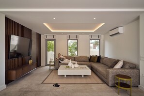 Un salon moderne avec un canapé d’angle, un téléviseur à écran plat et une table basse.