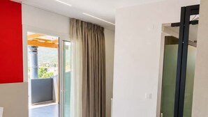 A modern hotel room with a bed, a bathroom, and a sliding glass door leading to a balcony. - New Horizon Sarti - Double Room with Balcony G2 (Sarti)