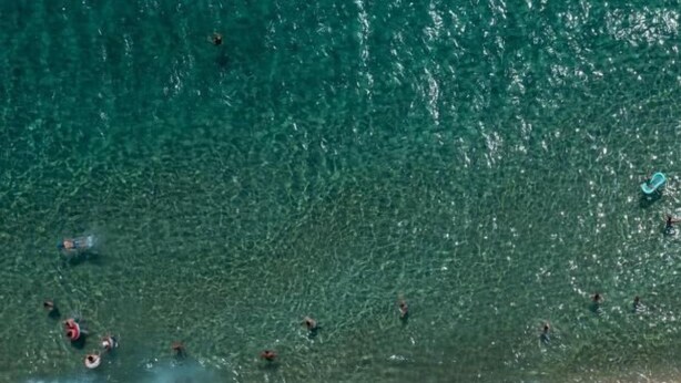 An aerial view of a beach with people swimming and sunbathing, and numerous colorful umbrellas and beach chairs. - New Horizon Sarti - Double Room with Balcony G2 (Sarti)